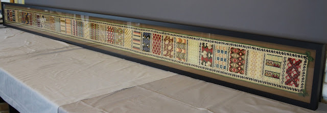 12 foot long Berlin work sampler, conserved, mounted and framed. Textile conservation of Berlin work sampler featuring Bargello needlework. Conservator Gwen Spicer of Spicer Art Conservation custom mounted the unusually sized textile sampler