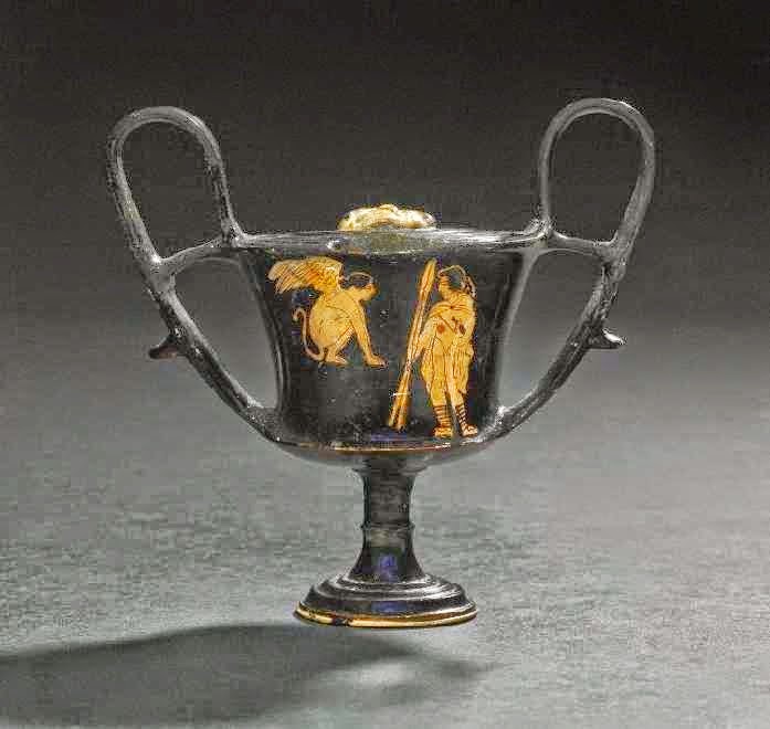 Οιδίποδας και Σφίγγα. Αττικός κάνθαρος 440-430 π.Χ. Βρέθηκε στη Νόλα της Ιταλίας. Η Σφίγγα κάθεται πάνω σε βράχο. Μπροστά της ο Οιδίποδας, φορώντας χλαμύδα και με δύο δόρατα στο δεξί του χέρι, απαντά στο αίνιγμα. Λονδίνο, Βρετανικό Μουσείο, 1867,0508.1132 / E156 © Trustees of the British Museum