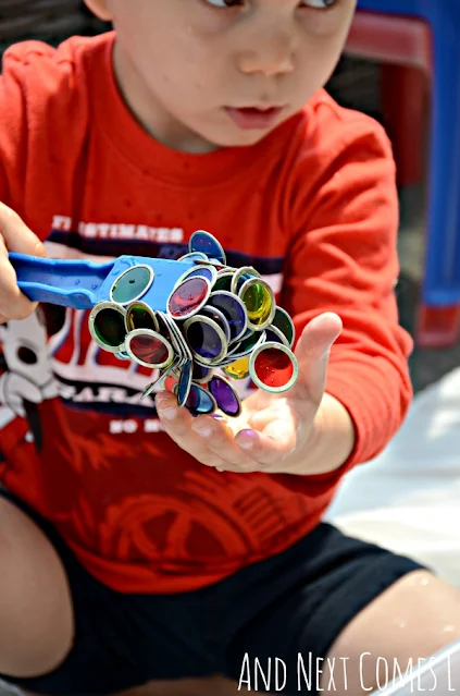 Child holding a magnetic wand covered with magnetic transparent counters