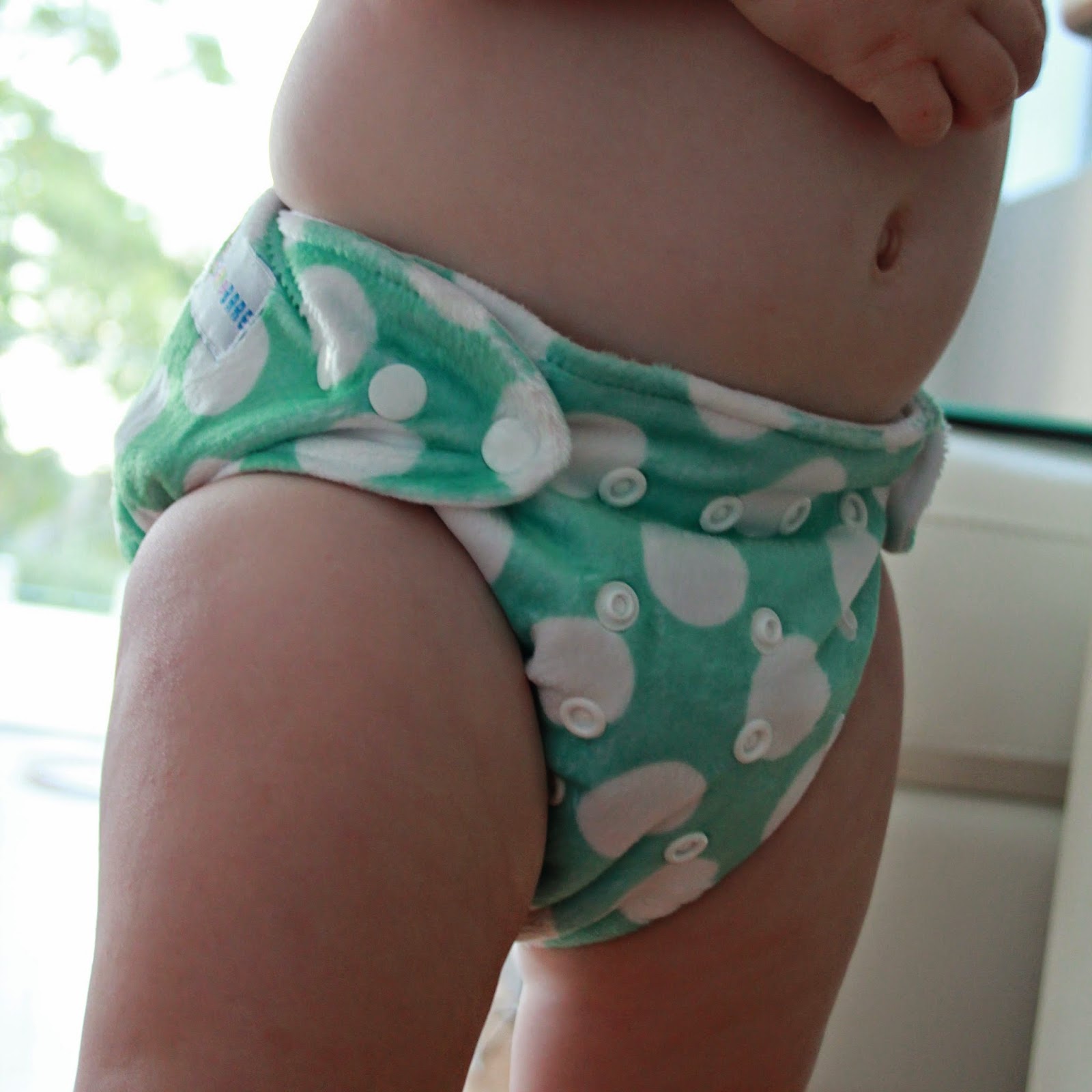 You can see the snaps across the front of this nappy and how the wings wrap around to the front to snap the nappy on to your child.