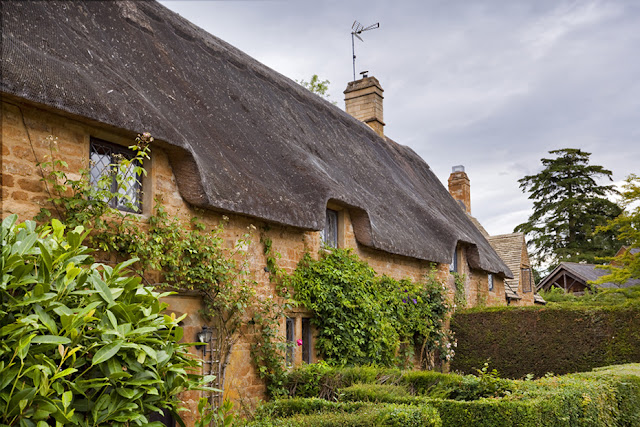 Thatched cottages made from local iron stone in Great Tew by Martyn Ferry Photography