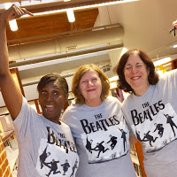 Beatles fans at Olney Library Three Olney staff members in grey shirts labelled the Beatles with images of the band members