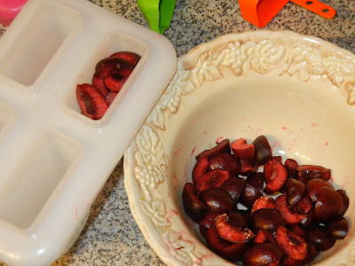 chopped cherries in a bowl with some in a popsicle mold 