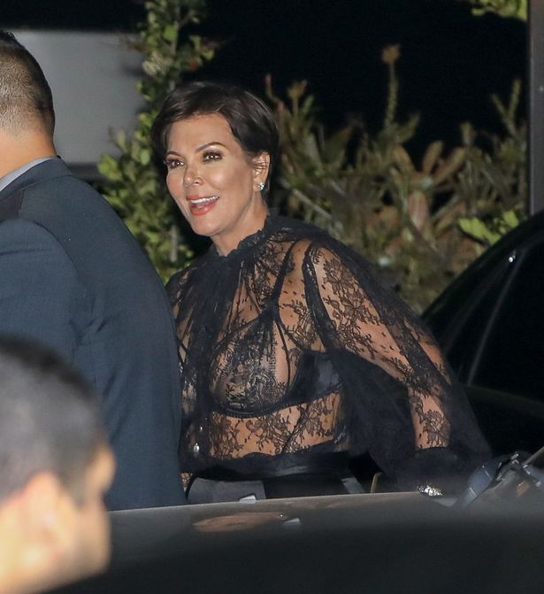 Kris Jenner flaunts lacy bra in sheer blouse.
