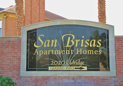 San Brisas Apartments (sign on red brick wall)