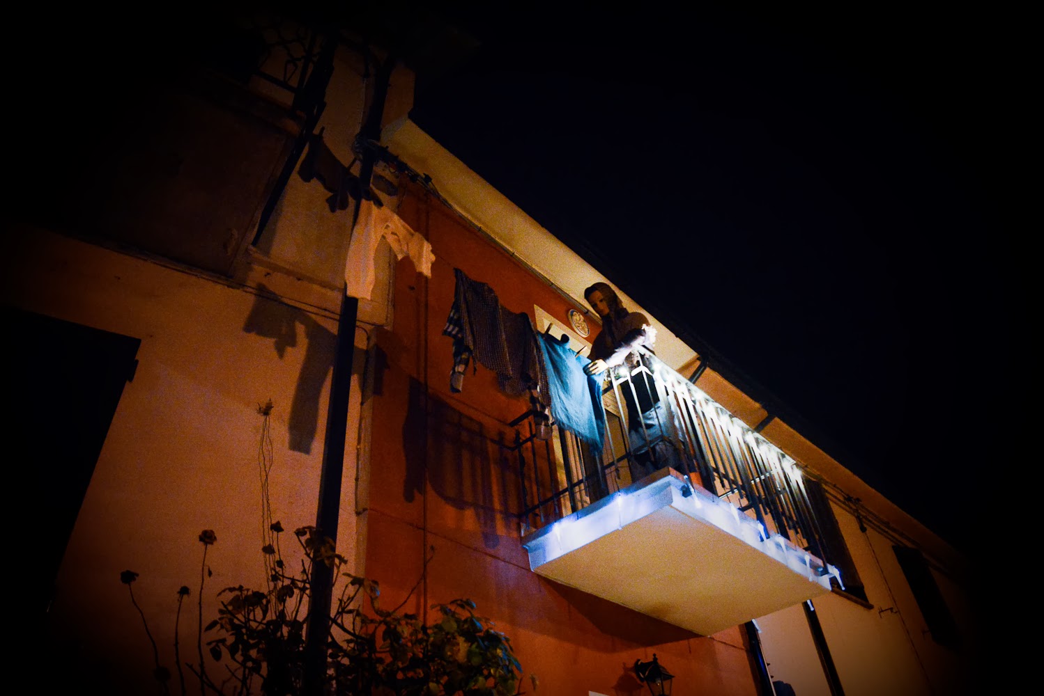 presepe di Roversano Una statua sul balcone di una casa mentre stende i panni