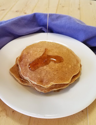 Pancakes loaded with the good stuff, whole grains, banana, yogurt and no added sugar! They are soft and flavorful and ready to be your breakfast! drizzling syrup on whole grain banana yogurt pancakes