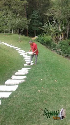 Bizzarri trabalhando, fazendo um caminho de pedra no jardim, sendo caminho com cacão de Goiás com junta de grama em casa em condomínio na Cantareira. 1 de fevereiro de 2017.
