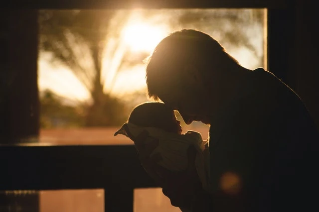 A silhouette of a father and his baby