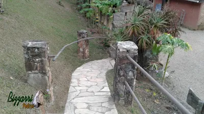 Caminhos com pedras caco de São Tomé com o corrimão de ferro preso nos pilares de pedra em sítio em Atibaia-SP.