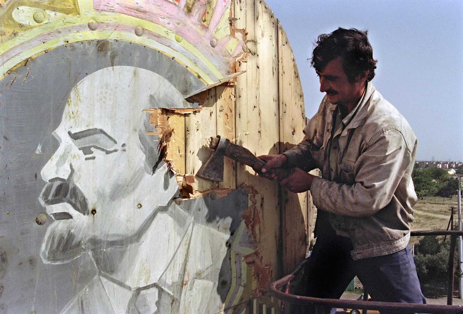 A Baku resident uses an axe to hack apart a placard showing a portrait of Russian Bolshevik revolutionary leader Vladimir Lenin, on September 21, 1991. Azerbaijan was proclaimed a Soviet Socialist Republic by Soviet Union in 1920. The Azeri National Council voted for its declaration of independence in 1991.