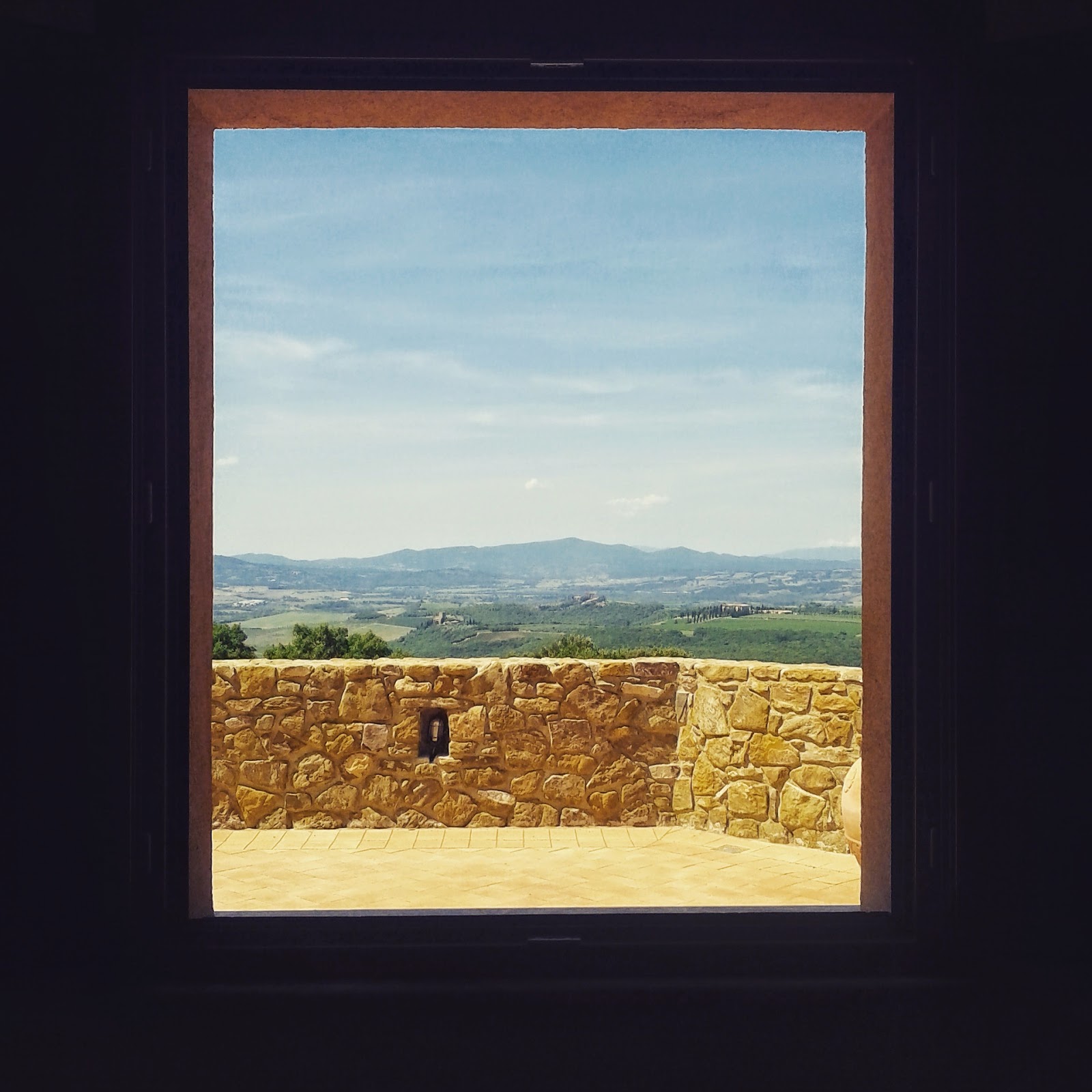 The Tuscan landscaped seen through the window of a winery