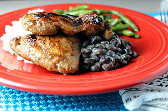 Grilled Jerk Chicken Thighs by Renee's Kitchen Adventures on a red plate with white rice, black beans and green beans