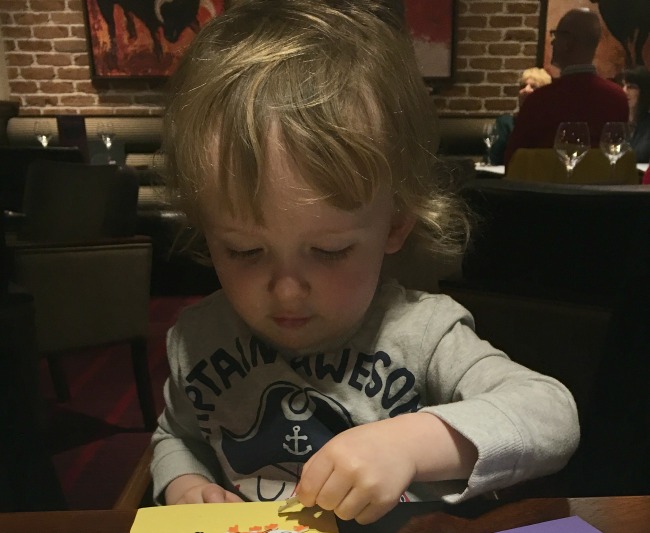 toddler sat at table with stickers