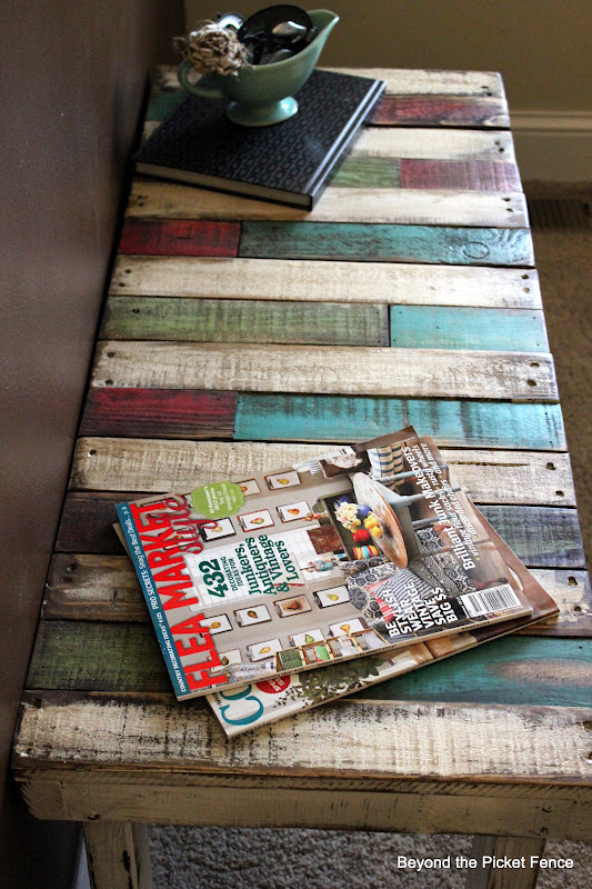 This pallet bench is stained with colorful tones for a super creative look