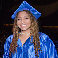 Image of a smiling female grad in cap and gown