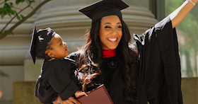 African American mother holding her child at her college graduation