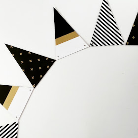 Set of triangular wooden bunting in black, white and gold patterns.