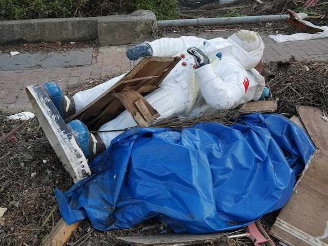 disposed statue of an astronaut on the ground