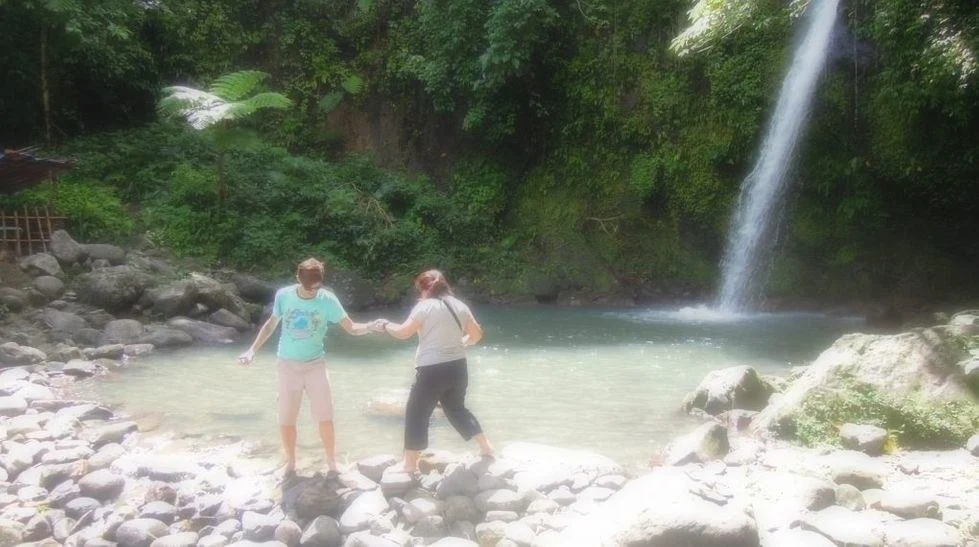 A couple enjoying the water of Vera Falls in Albay