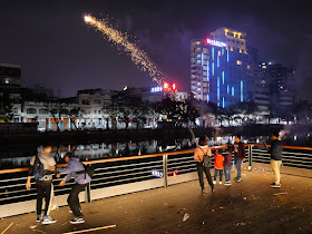people light fireworks next to the river during the Lunar New Year in Jiangmen