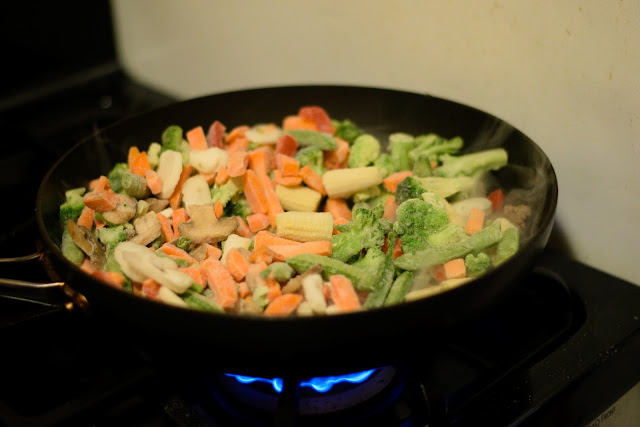 Frozen vegetables in the pan with the ground beef. 