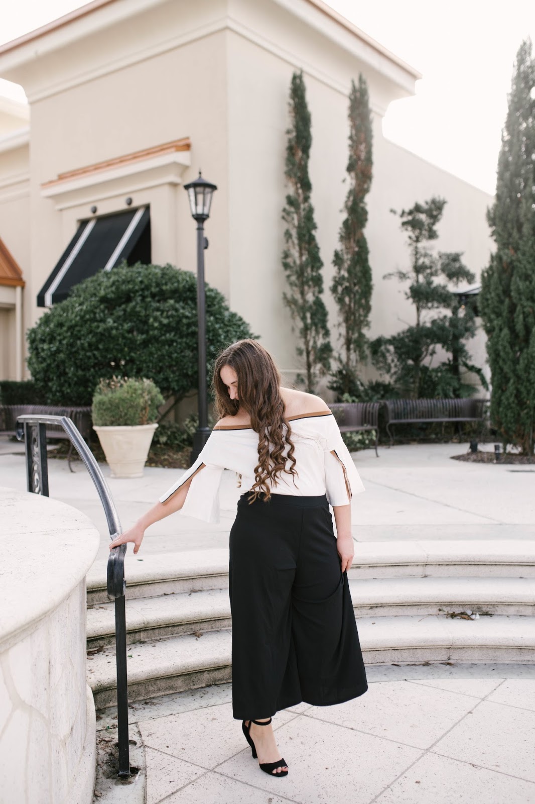 Girl wearing black culotte pants and off the shoulder top