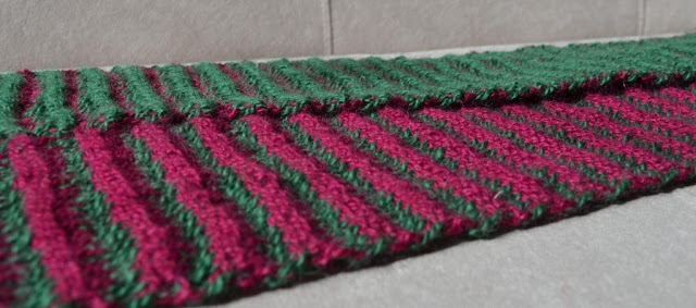 A close-up, side view of the scarf showing the neat edges where the stripes swap colours. Foreground: red ridges and green valleys. Background: green ridges and red valleys.