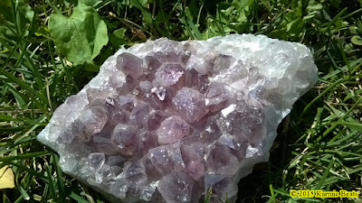 Amethyst crystal druse sitting in grass