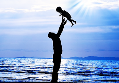 pai levantando filho na praia