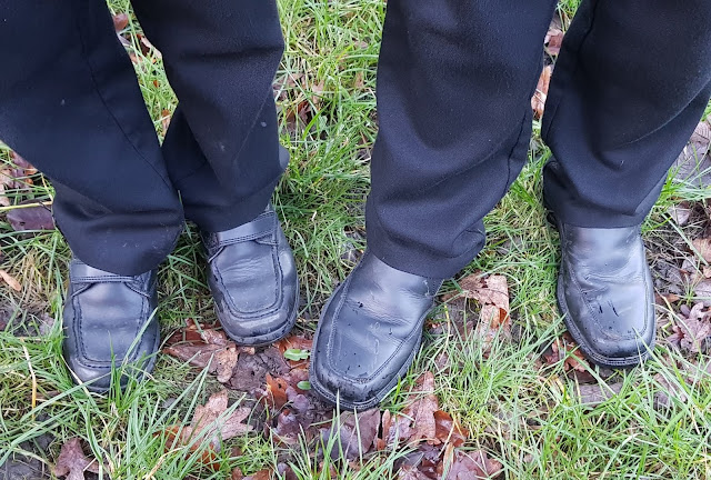 two boys feet on grass showing their school shoes aged 9 months
