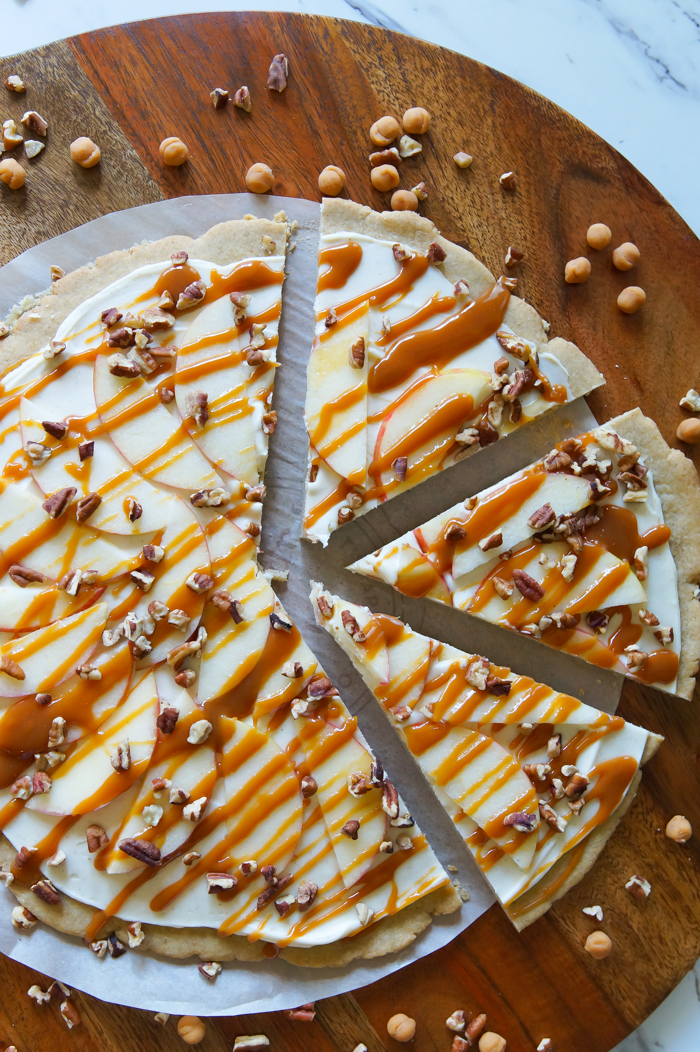 Honeycrisp Caramel Apple Pizza recipe: a spiced cookie crust, cream cheese spread, caramel sauce, toasted pecans, and of course, Honeycrisp apples.