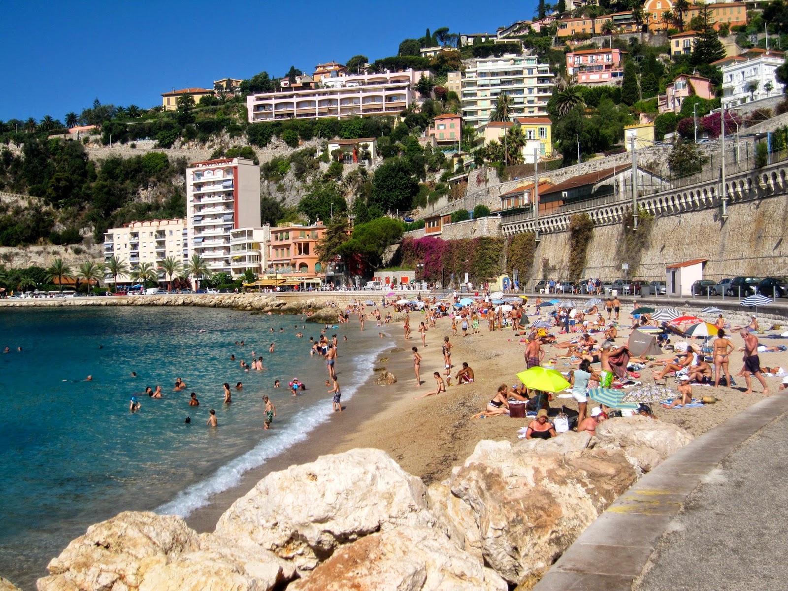 Destination Fiction The Beach Of Villefranche Sur Mer This Veolia Boat Was Cleaning Debris From The Water With Its Large Nets Under A Cascade Of Bougainvillea Sign Proclaims Good Quality