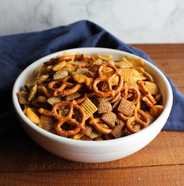 A classic crunchy and spicy cereal snack mix baked crispy in the oven. Chex mix is a Christmas time must have in our family, but we love it all year! bowl of classic chex with cereals, pretzels and peanuts mix ready to eat