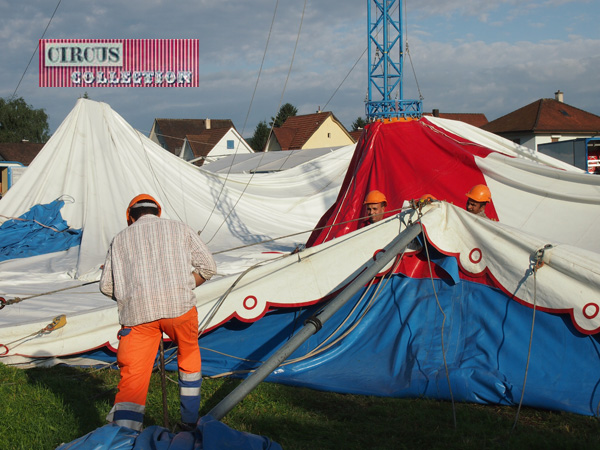 les ouvriers du cirque dressent les mats de pour tour de la tente 