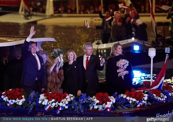 Dutch King Willem Alexander, Princess Beatrix, Queen Maxima (R), Canadian Prime Minister Stephen Harper and his wife Laureen Haper wave as they leave on a boat after attending the Dutch 5th of May Liberation concert in Amsterdam on May 5, 2015