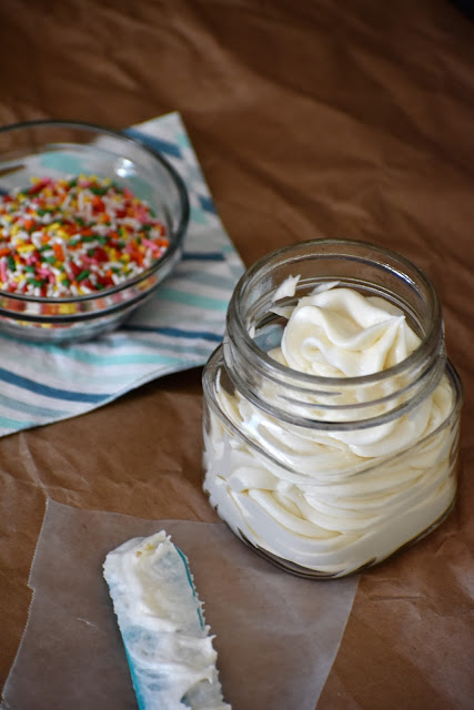 vanilla buttercream in a jar with sprinkles next to it