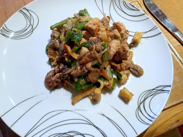 chicken stir fry with black bean sauce, served on a white plate