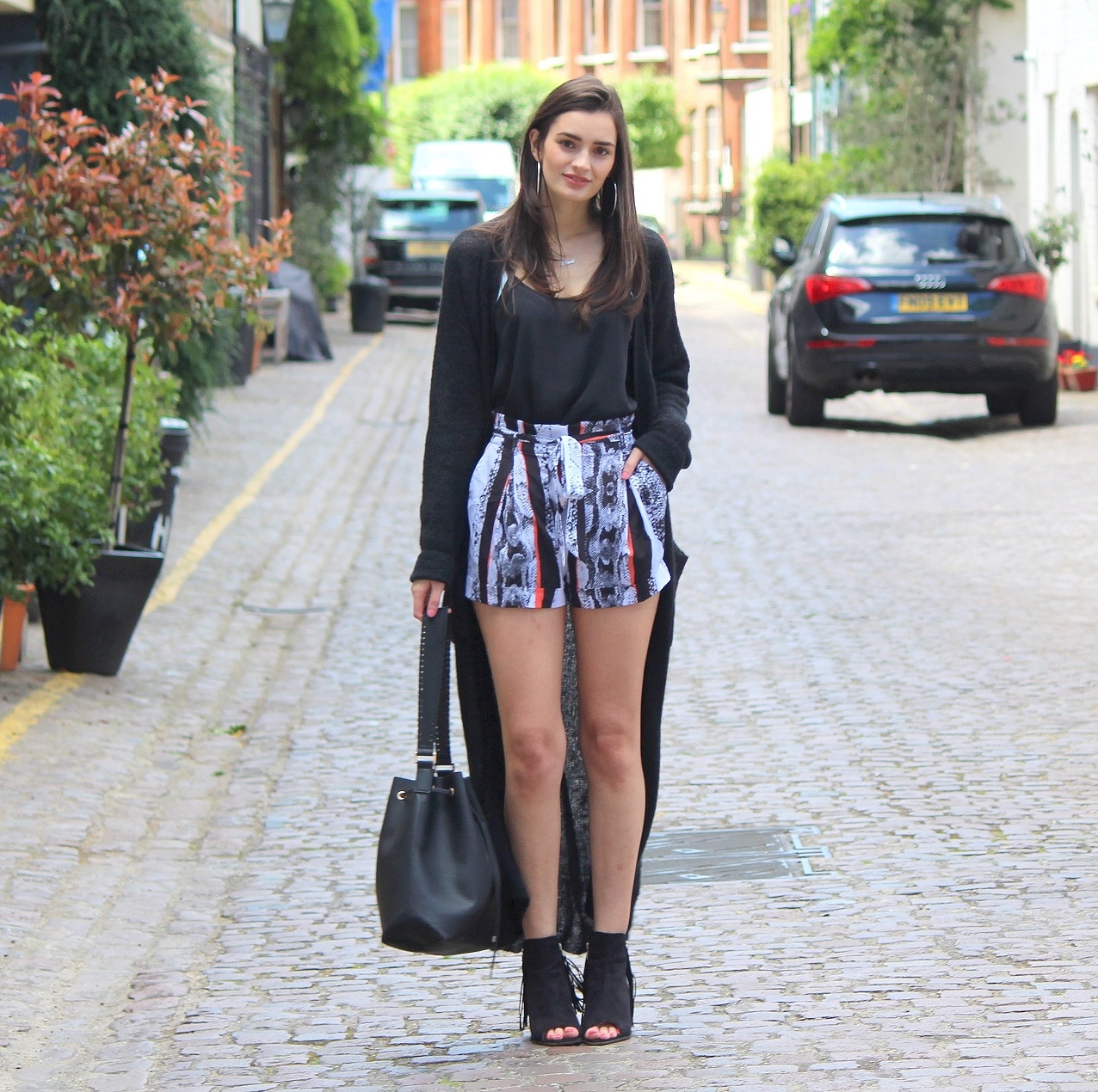 peexo fashion blogger in monochrome longline cardigan and reiss shorts and bucket bag and fringe boots