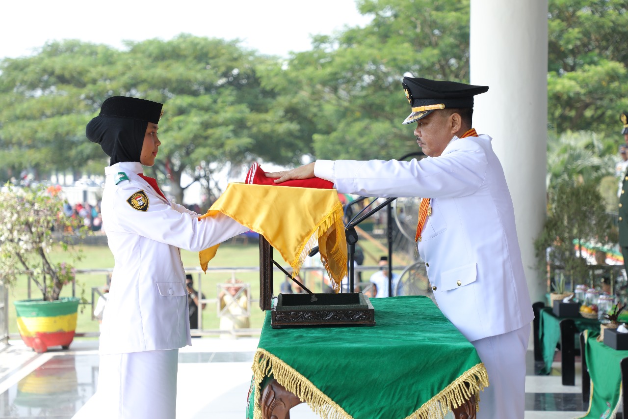 Bupati Asahan Taufan Gama Simatupang menyerahkan Bendera Merah Putih kepada anggota Paskibra untuk dikibarkan. Bupati Asahan Taufan Gama Simatupang menyerahkan Bendera Merah Putih kepada anggota Paskibra untuk dikibarkan.