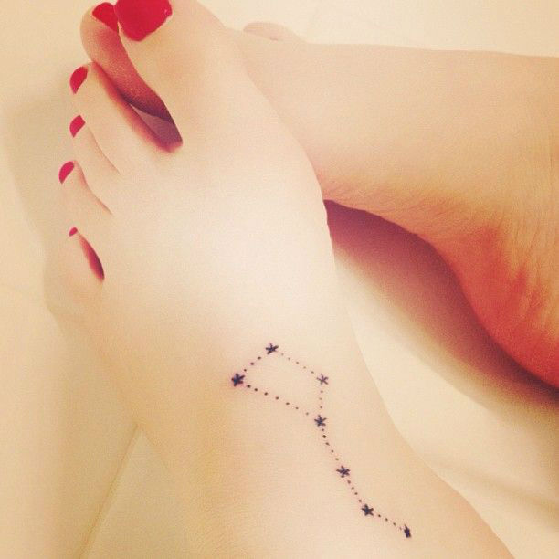 chica con tatuaje en el pie, el tatuaje es de una constelacion