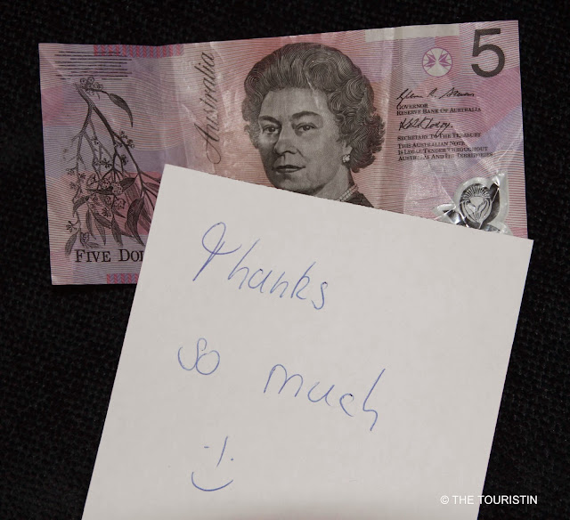A handwritten thank you note with a smiley on an Australian five-dollar banknote.