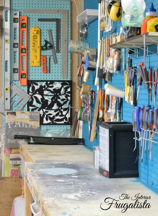 A basement workshop tour with vibrant painted pegboard walls for level and carpentry square organization.