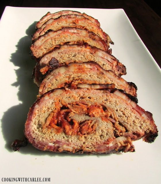 This bacon explosion is for the birds! It is made with turkey instead of pork. It's almost like a yummy jazzed up and rolled up meatloaf that is smoked to yummy perfection. slices of turkey bacon explosion on platter ready to eat