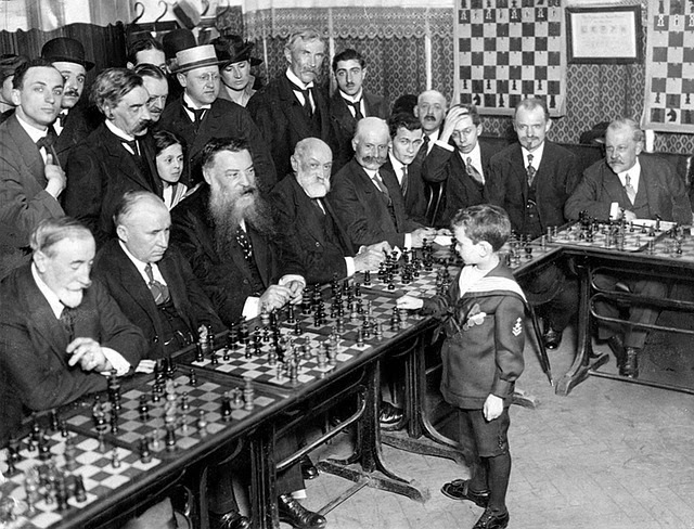 Niño genio jugando ajedrez contra personas adultas