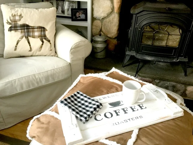 White coffee tray in front of chair and wood burning stove