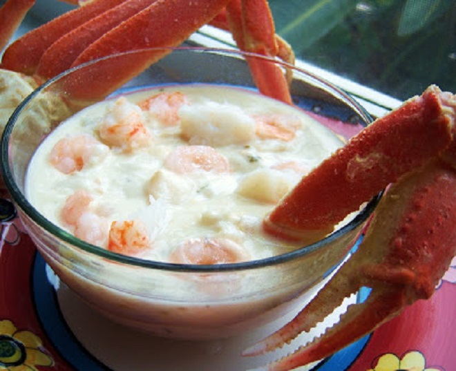 this is a white chowder with shrimp, crab legs, lobster, scallops and white fish . This is a cream soup loaded with butter and lots of fish in a glass bowl
