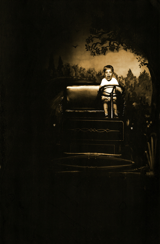 Little boy sits in a wagon. 1968.