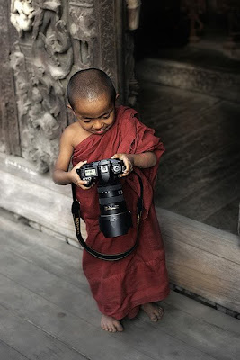 Un pequeño niño monje con su cámara Nikon en Tailandia