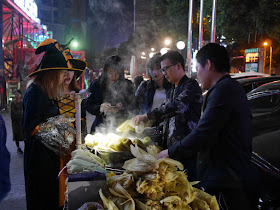 two young women dressed up for Halloween buying corn in Changsha